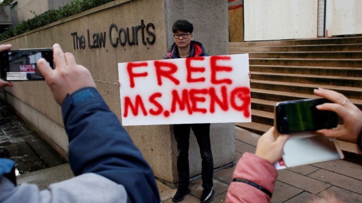 Một người giơ khẩu hiệu kêu gọi trả tự do cho bà Meng Wanzhou, CFO Huawei, trước tòa án ở Canada ngày 11/12 - Ảnh: Reuters.