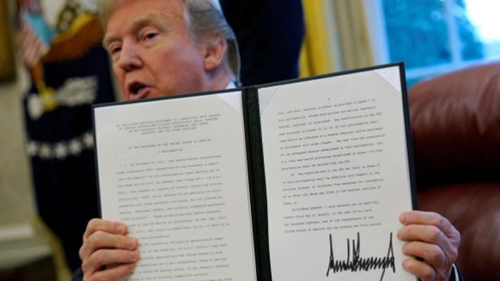 Tổng thống Mỹ Donald Trump và sắc lệnh mà ông ký về áp thuế quan lên máy giặt và tấm pin năng lượng mặt trời nhập khẩu vào Mỹ, tại Nhà Trắng, hôm 23/1/2018 - Ảnh: Reuters.