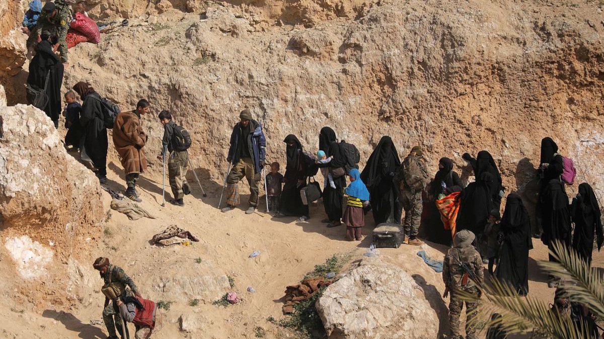Chiến binh IS và gia đình ra đầu hàng ở Baghouz - Ảnh: Reuters.