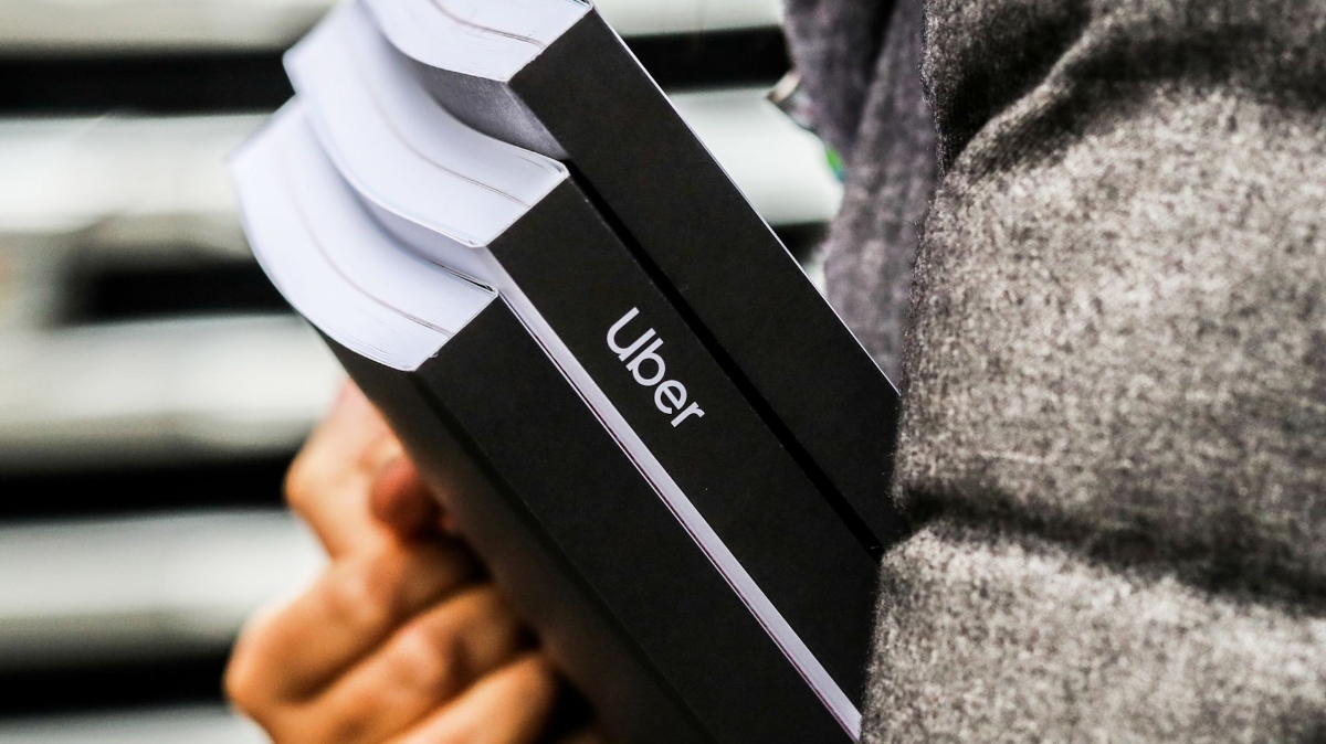 Một nhà đầu tư ở New York, Mỹ cầm tài liệu về vụ IPO sắp tới của Uber - Ảnh: Reuters/CNBC.