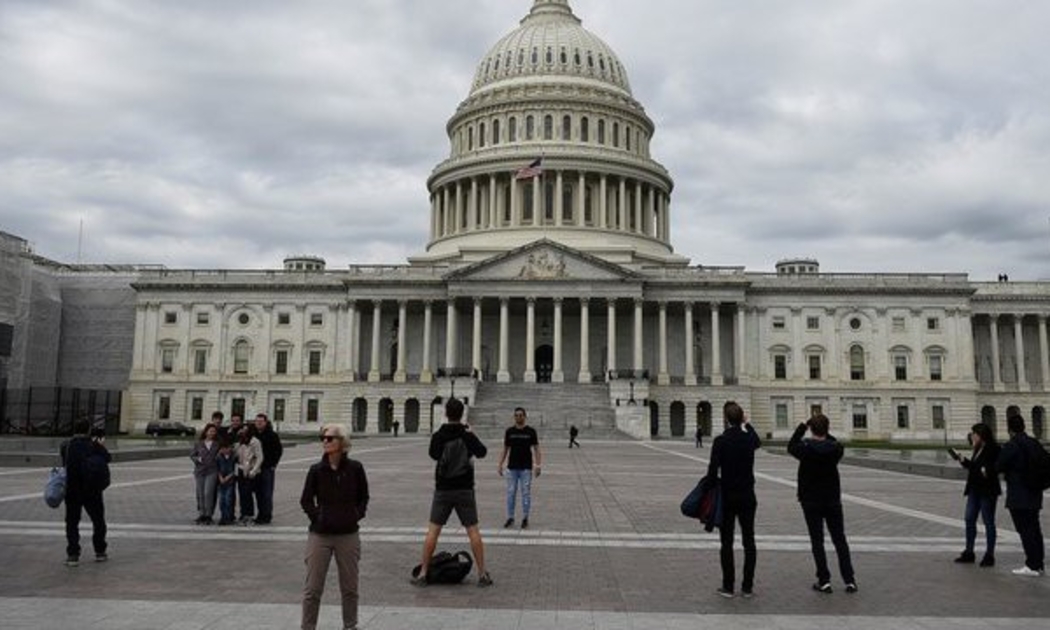 Du khách chụp ảnh trước tòa nhà Quốc hội Mỹ trên đồi Capitol ở Washington DC - Ảnh: Reuters.