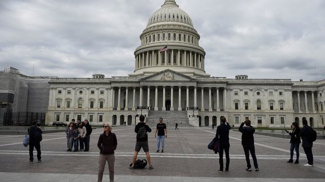 Du khách chụp ảnh trước tòa nhà Quốc hội Mỹ trên đồi Capitol ở Washington DC - Ảnh: Reuters.