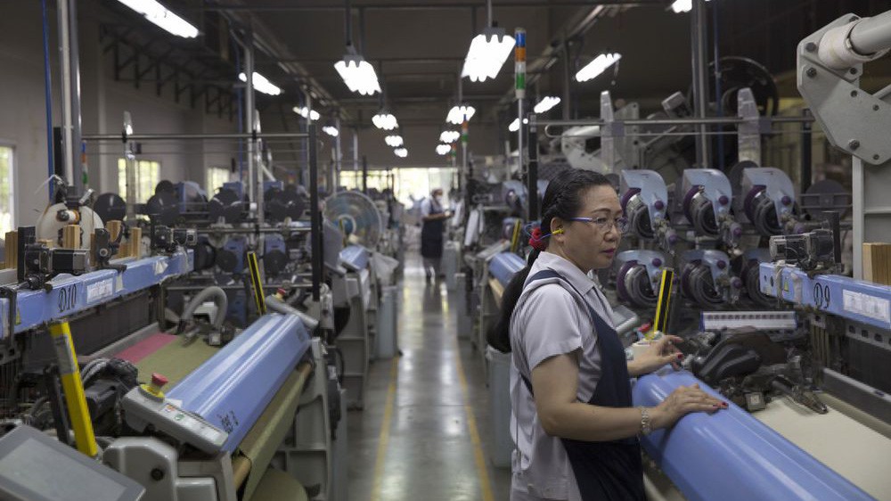 Công nhân làm việc trong một nhà máy dệt ở Pak Thong Chai, Thái Lan - Ảnh: Bloomberg.