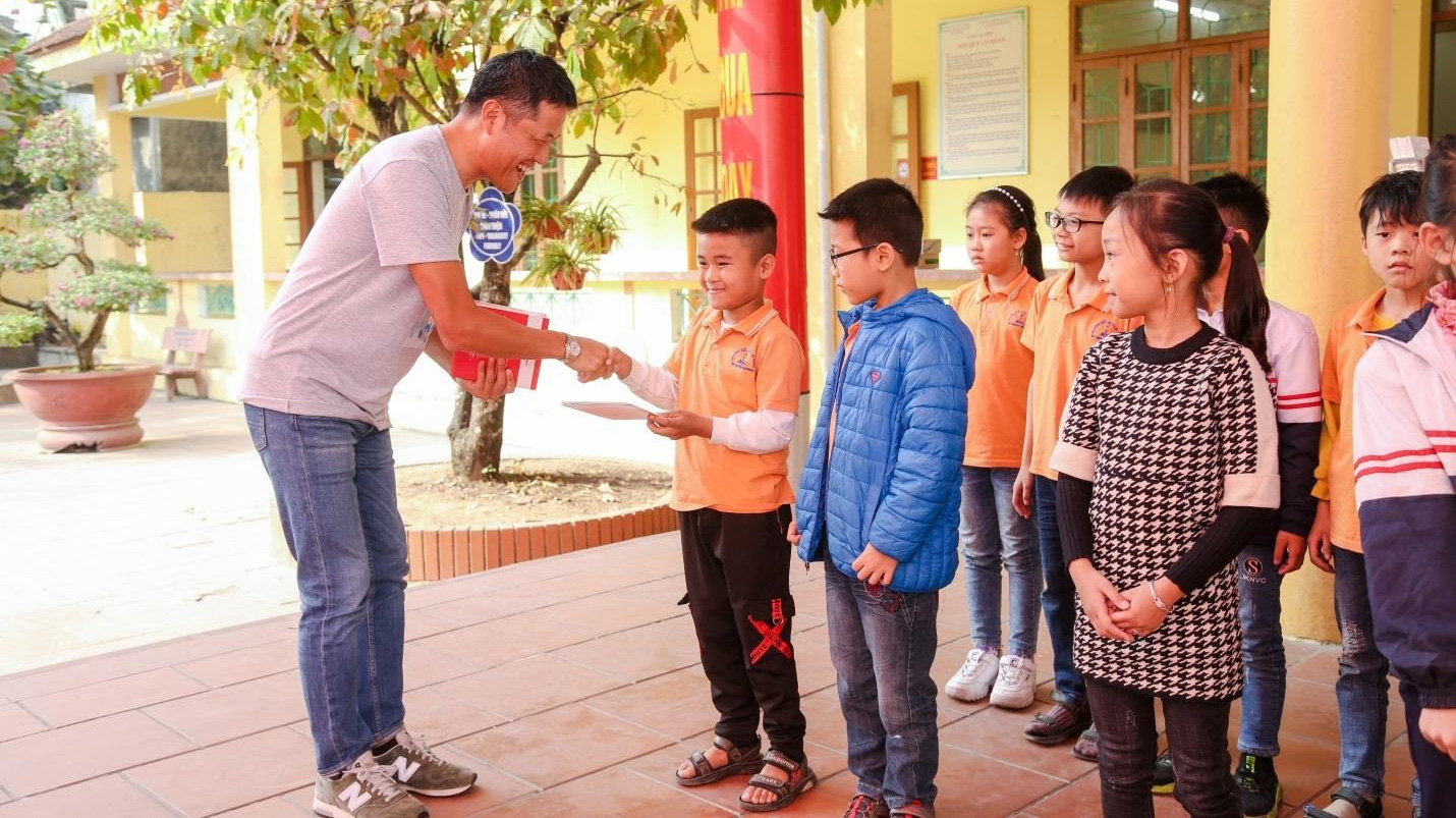 Tổng giám đốc Fuji Xerox Việt Nam, ông Yanagiya Masaaki trao tặng bộ sách truyện cho các em tại trường Tiểu Học Lại Xuân, huyện Thủy Nguyên, Hải Phòng.