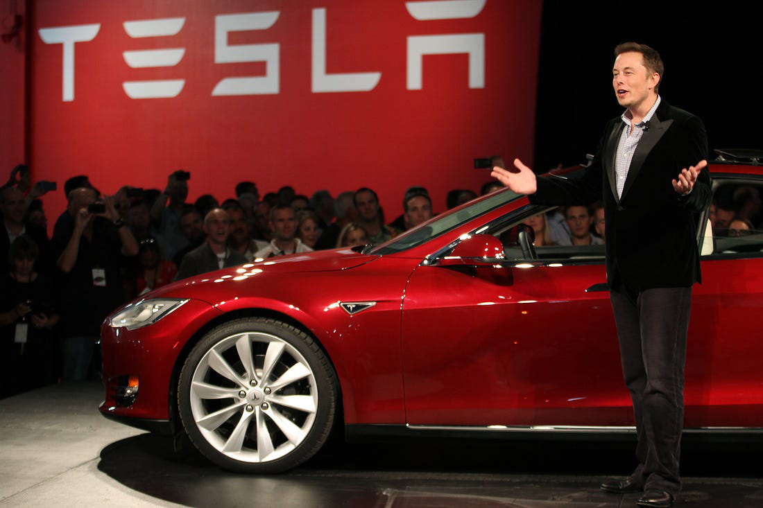 CEO Elon Musk của Tesla bên một mẫu xe điện do hãng này sản xuất - Ảnh: Reuters.