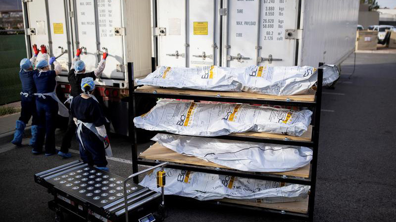 Các nhân viên y tế đóng cửa thùng xe lạnh sau khi đưa xác bệnh nhân tử vong vì Covid-19 khỏi xe lạnh để chuyển vào nhà xác ở El Paso, Texas, Mỹ, hôm 23/11 - Ảnh: Reuters.