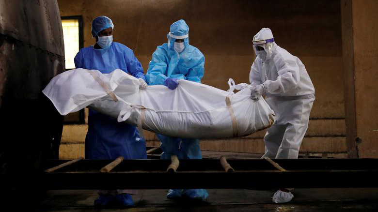 Các nhân viên y tế đang di chuyển thi thể một bệnh nhân Covid-19 ở Ấn Độ - Ảnh: Reuters.