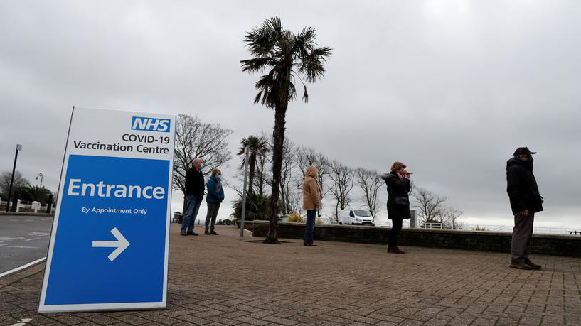Người dân xếp hàng chờ tiêm vaccine Covid-19 tại một điểm tiêm chủng ở Anh - Ảnh: Reuters.