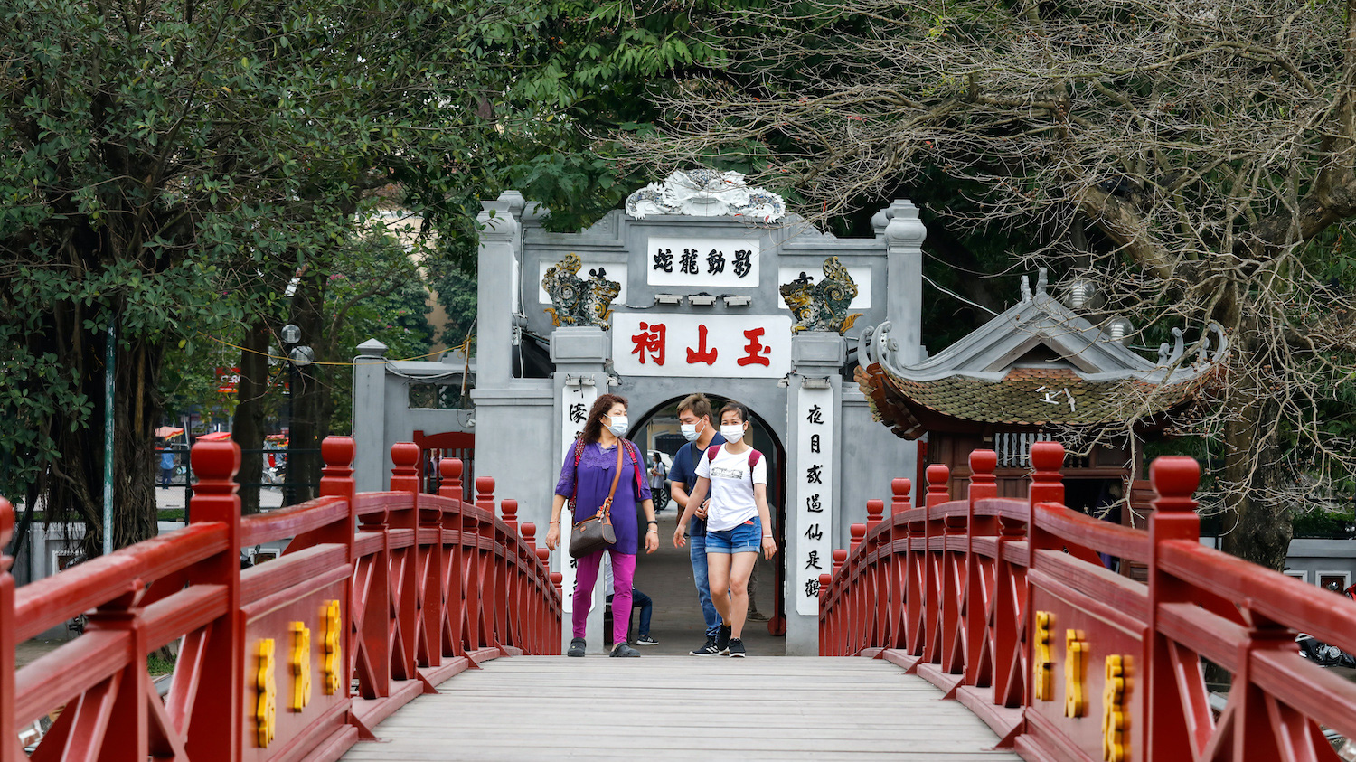 Du khách nước ngoài tại cầu Thê Húc, hồ Hoàn Kiếm, Hà Nội vào đầu tháng 3/2020 - Ảnh: Reuters