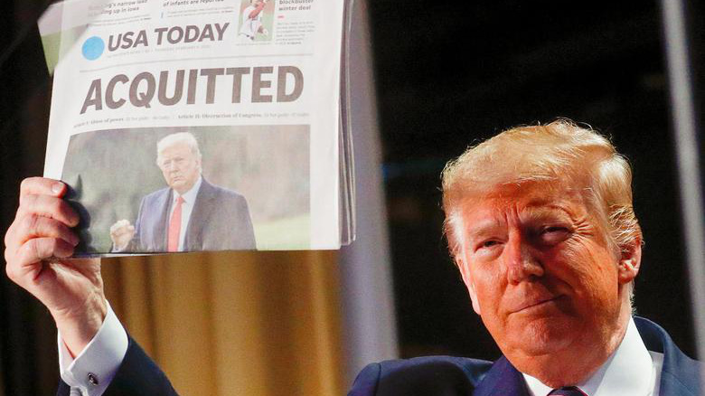Tổng thống Mỹ Donald Trump giơ một tờ báo USA Today đưa tin ông được Thượng viện tha bổng trong cuộc luận tội đầu tiên, hôm 6/2/2020 - Ảnh: Reuters.