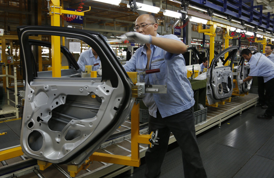 Công nhân làm việc trong một nhà máy liên doanh lắp ráp xe Ford ở Trùng Khánh, Trung Quốc.<br>
