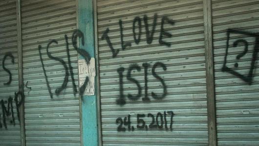 Dòng chữ ghi "tôi yêu ISIS [một tên gọi khác của tổ chức khủng bố IS]" trên bức tường một ngôi nhà ở Marawi, Philippines - Ảnh: Getty/CNBC.<br>
