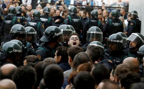 Cử tri Catalonia đụng độ với cảnh sát quốc gia Tây Ban Nha trong cuộc trưng cầu dân ý ngày 1/10 - Ảnh: Reuters.<br>