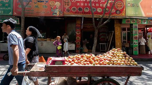 Một người đàn ông kéo xe chở hoa quả trên đường phố Urumqi, thủ phủ khu tự trị Tân Cương, Trung Quốc - Ảnh: Getty/CNBC.<br>