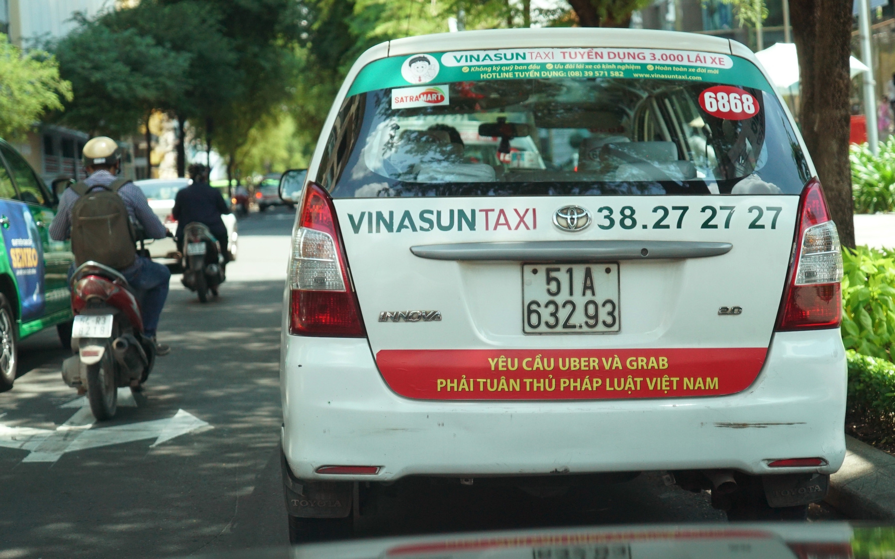 Mới đây, hàng loạt taxi của hãng treo khẩu ngữ đòi Uber, Grab phải "tuân thủ pháp luật Việt Nam", và đã tháo gỡ sau khi có nhiều chỉ trích hành động này từ dư luận - Ảnh: Tuổi Trẻ.