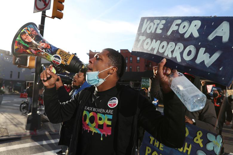 Clive Destiny, nhà sáng lập tổ chức Unite Ny, đi tới các điểm bầu cử ở khu Brooklyn, New York để kêu gọi cử tri đi bỏ phiếu - Ảnh: Reuters.