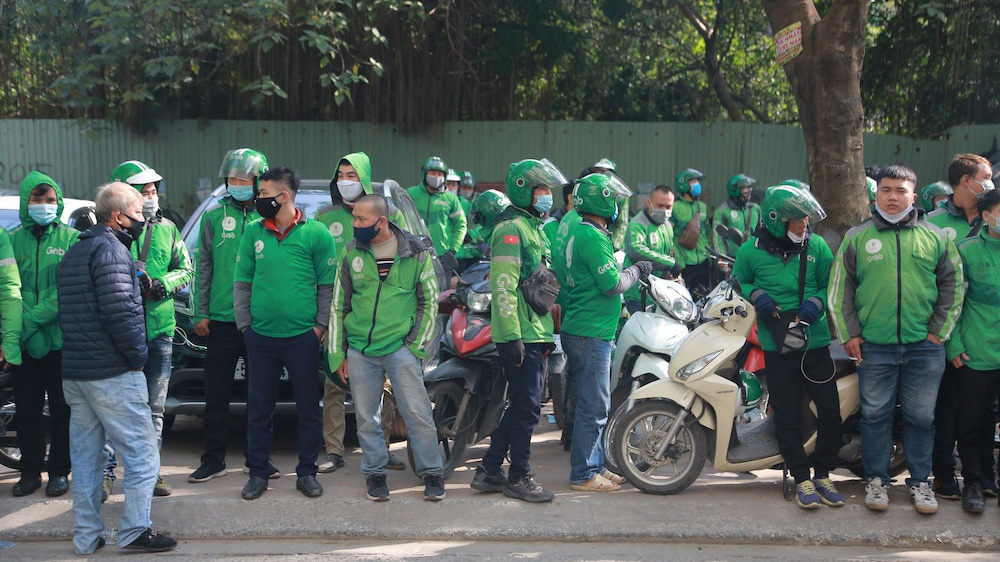 Hàng trăm tài xế Grab tập trung trước trụ sở của Grab tại ngõ 78 phố Duy Tân sáng 7/12 để phản đối mức khấu trừ mới mà hãng này áp dụng.