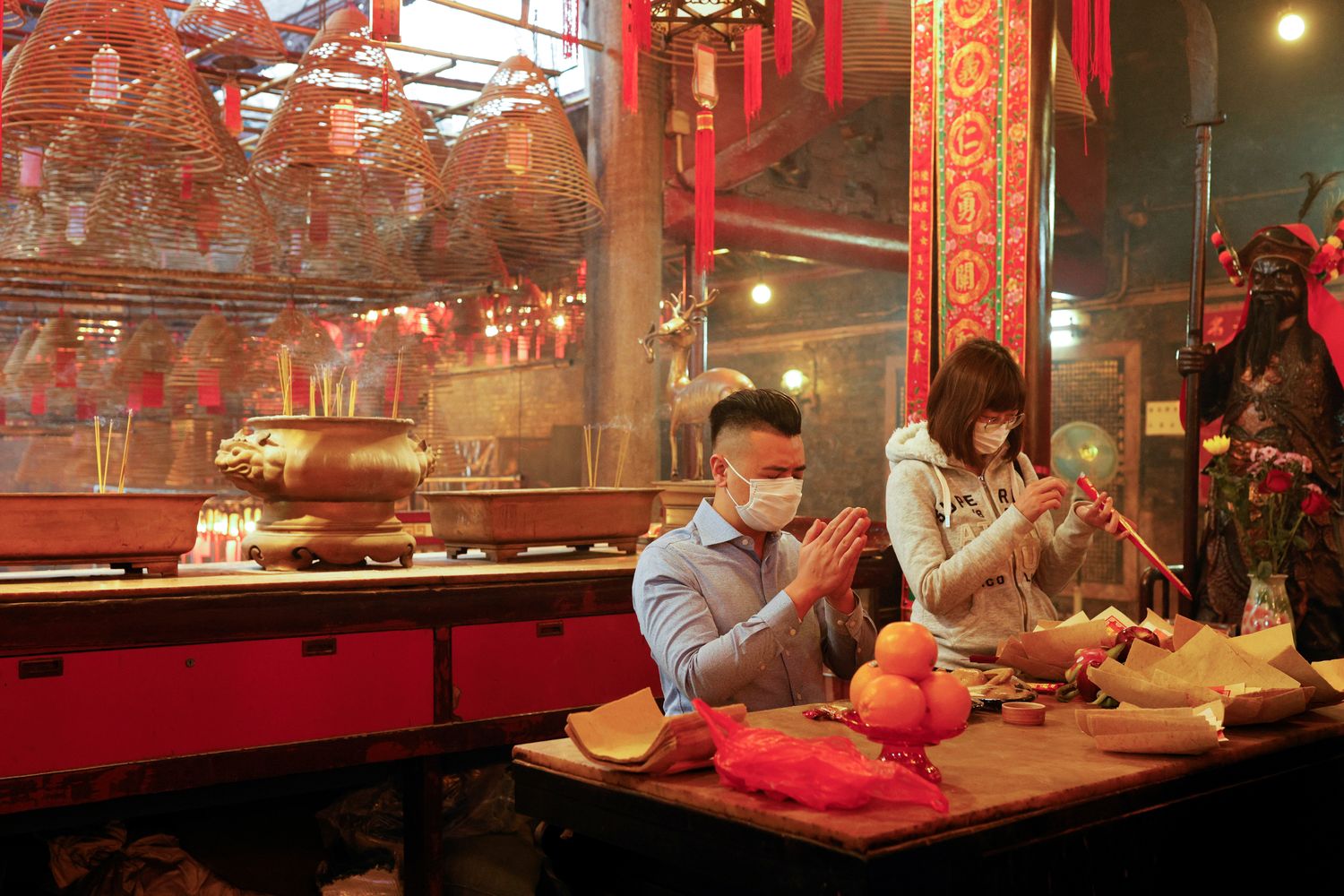 Người dân đeo khẩu trang làm lễ trước thời khắc bước sang năm mới Tân Sửu tại đền Man Mo, Hồng Kông, Trung Quốc - Ảnh: Reuters