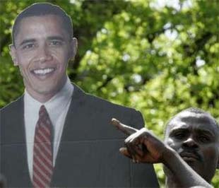 Một người đàn ông ở làng Kogelo (Kenya) - quê cha của Obama - giơ cao tấm biểu ngữ in hình vị Tổng thống mới đắc cử của nước Mỹ - Ảnh: Reuters.