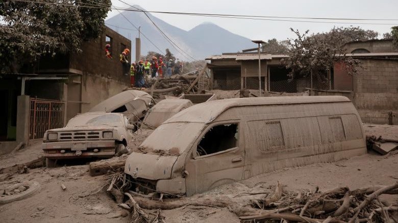 Nhà cửa và xe cộ tại một ngôi làng Guatemala bị vùi lấp trong tro bụi và nham thạch núi lửa - Ảnh: Reuters.