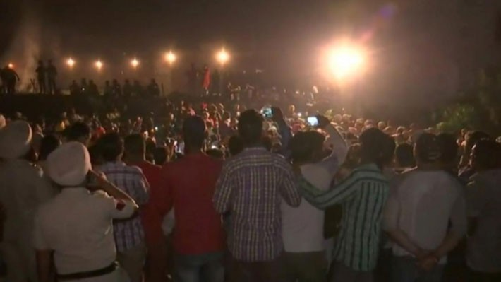 Ảnh cắt từ video cho thấy đám đông tụ tập trên đường ray để xem đốt bù nhìn trước khi đoàn tàu lao tới - Ảnh: Reuters.