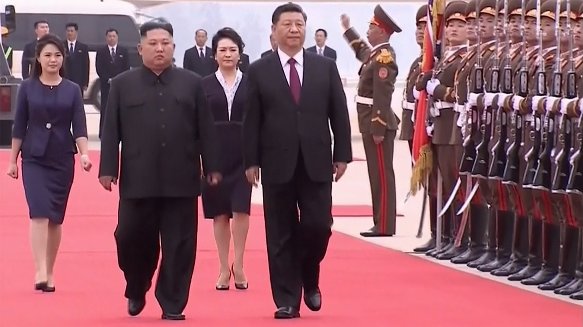 Nhà lãnh đạo Triều Tiên Kim Jong Un (trái) đón Chủ tịch Trung Quốc Tập Cận Bình sang thăm ngày 20/6 - Ảnh: AP/Bloomberg.