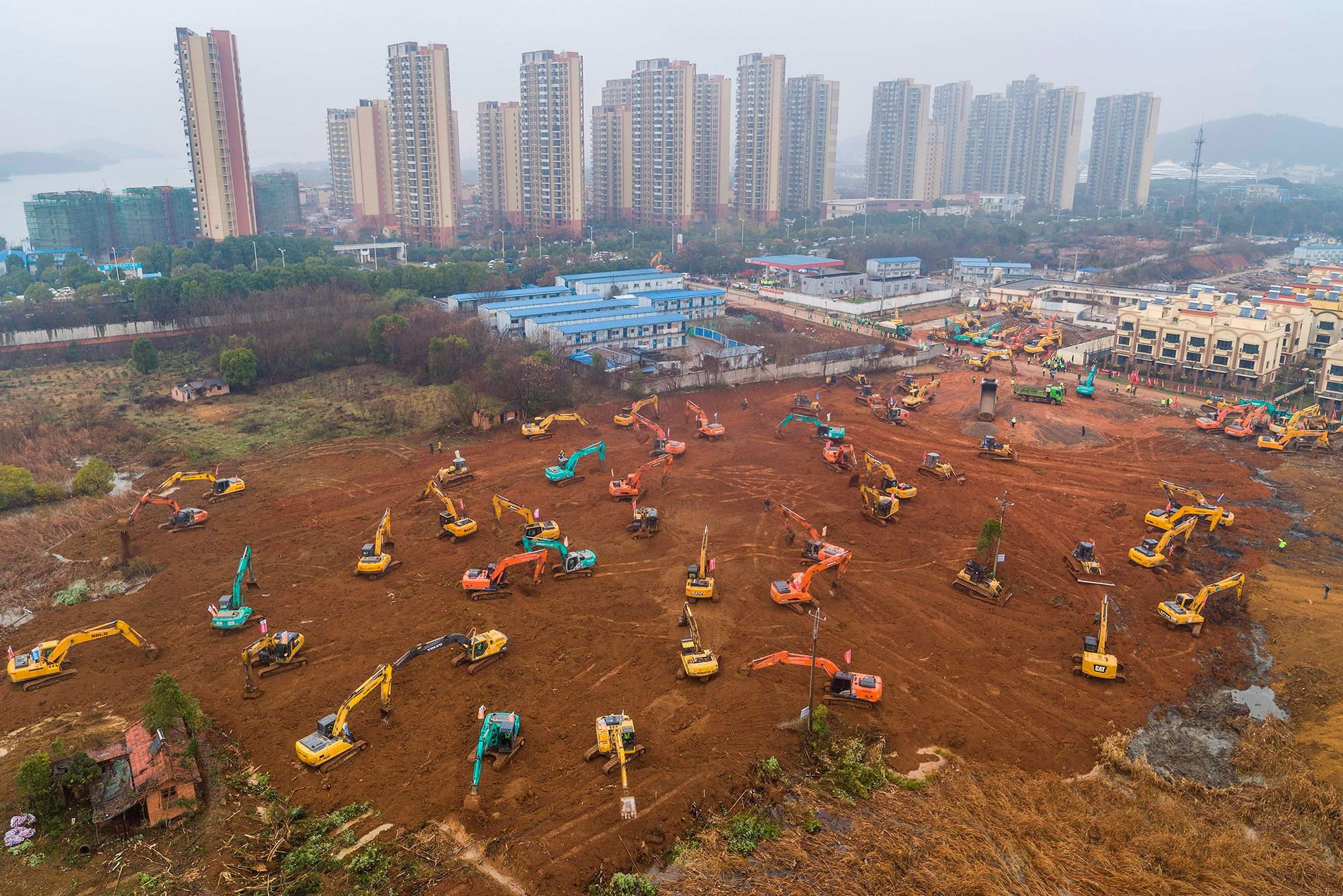 Đại dịch Covid-19 bùng phát tại Vũ Hán, Trung Quốc và bắt đầu lan nhanh ra toàn cầu. Để ứng phó với dịch bệnh chưa từng có trong lịch sử, Trung Quốc nhanh chóng cho xây dựng các bệnh viện dã chiến để chữa trị cho các bệnh nhân Covid-19. Trong ảnh là công tác khởi công xây dựng một bệnh viện dã chiến vào ngày 24/1 với 7.000 công nhân làm việc ngày đêm. Truyền thông quốc gia Trung Quốc đã thực hiện phóng sự trực tiếp từ công trường xây dựng. Bệnh viện dã chiến với 1.000 giường này hoàn thành chỉ sau 10 ngày - Ảnh: AFP