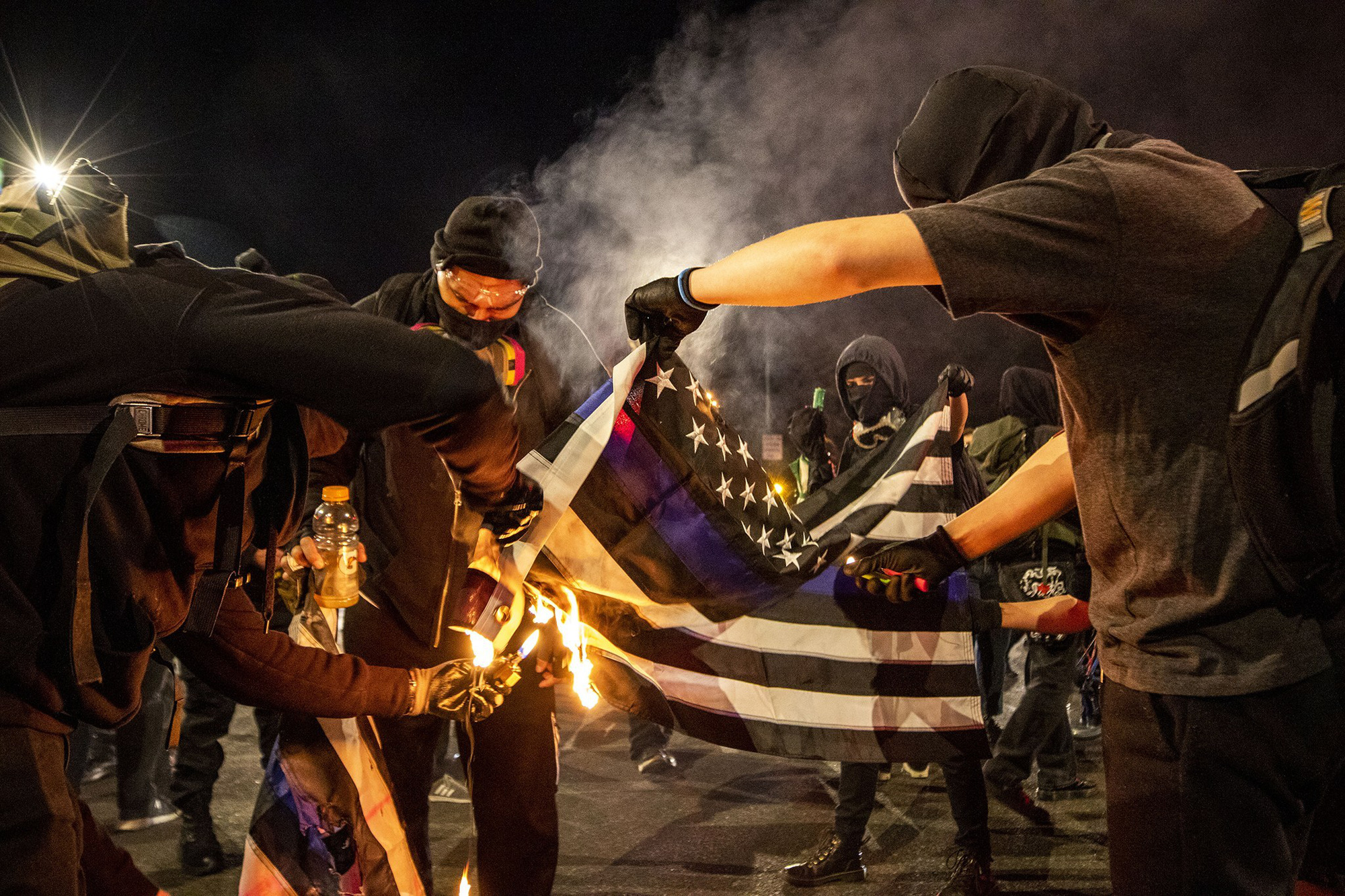 Nhóm người biểu tình phản đối cảnh sát và chính phủ, bất kể ai thắng cử, đốt cờ trên Đại lộ Đông Colfax, Denver, bang Colorado ngày 4/11 - Ảnh: AP