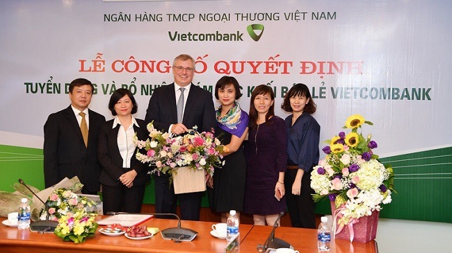 Vietcombank bổ nhiệm ông Thomas William Tobin (người ôm hoa trong ảnh) ở vị trí giám đốc điều hành khối dịch vụ bán lẻ. Đây là nhân sự lãnh đạo là người nước ngoài đầu tiên, trực tiếp tham gia điều hành và phát triển kinh doanh, trong lịch sử gần 55 năm hoạt động của ngân hàng này. 