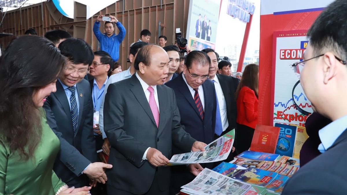 Thủ tướng Nguyễn Xuân Phúc, nguyên Tổng bí thư Nông Đức Mạnh, Chủ tịch Hội Nhà báo Việt Nam - Tổng biên tập Báo Nhân Dân Thuận Hữu và Phó chủ tịch Thường trực Hội Nhà báo Việt Nam Hồ Quang Lợi thăm gian trưng bày của Thời báo Kinh tế Việt Nam - Ảnh: Quang Phúc.