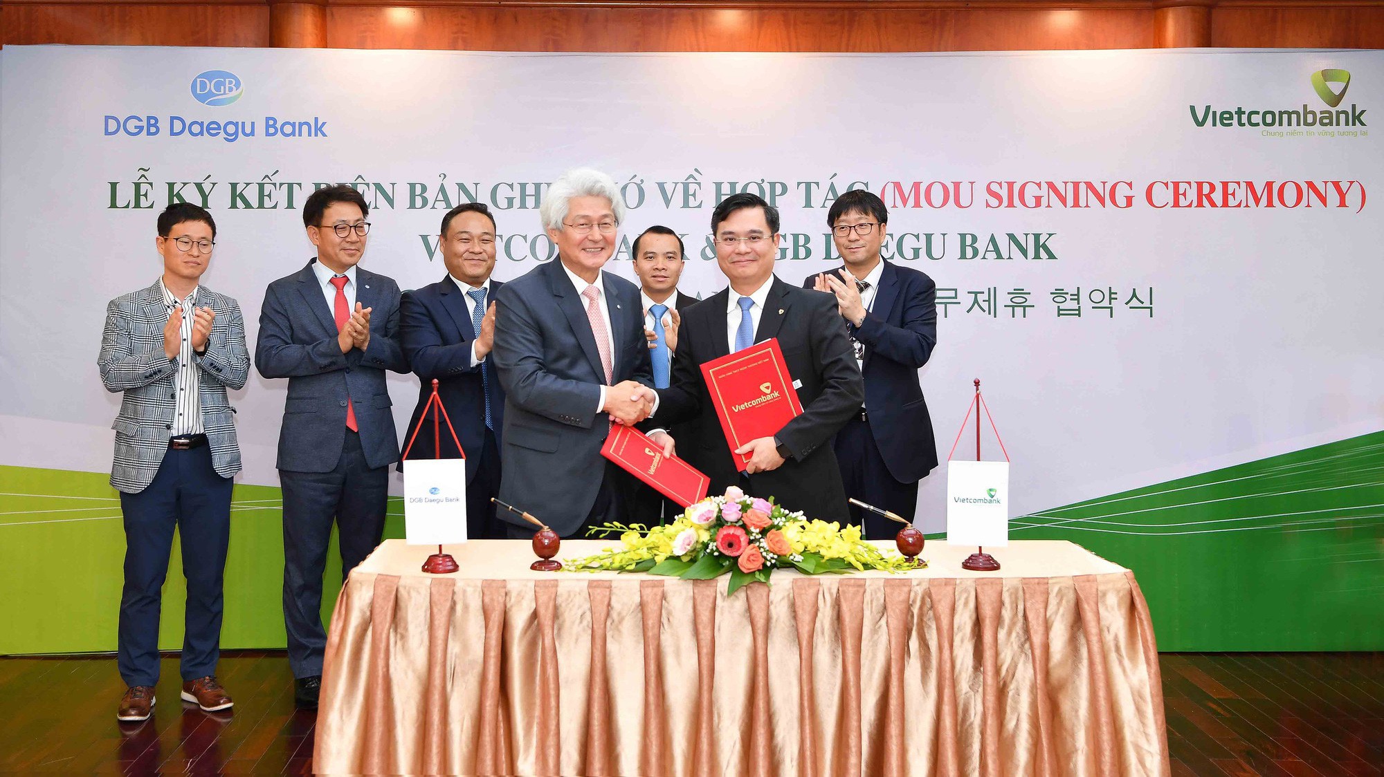 Ông Nguyễn Thanh Tùng - Phó Tổng giám đốc Vietcombank (hàng đầu, bên phải) và ông Kim Tae-oh - Chủ tịch Hội đồng quản trị kiêm Tổng giám đốc Tập đoàn DGB Financial Group, kiêm Tổng Giám đốc Ngân hàng DGB Daegu Bank đại diện 2 bên ký kết biên bản ghi nhớ.
