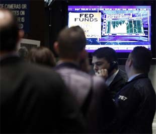 Nhà đầu tư tại Sở Giao dịch Chứng khoán New York theo dõi tuyên bố của FED trên màn hình.