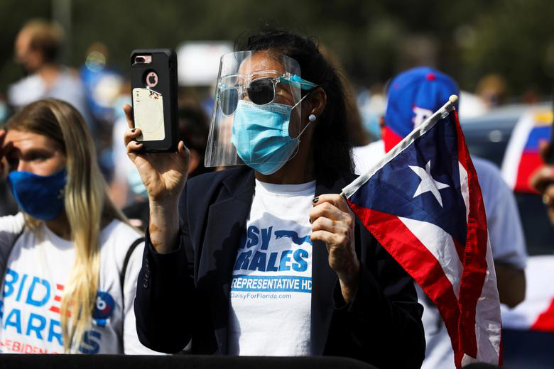Một người ủng hộ ông Biden cầm điện thoại và cờ Puerto Rico khi tham dự cuộc mít tinh do ông Barack Obama tổ chức để vận động thay mặt cho Joe Biden ở Orlando, Florida, ngày 27/10.