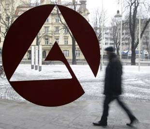 Một người đàn ông đi ngang qua biển hiệu một văn phòng hỗ người thất nghiệp tại Munich, Đức. Con số người thất nghiệp tại nước này đã tăng thêm 56.000 trong tháng 1, mức tăng mạnh nhất trong 4 năm qua - Ảnh: Reuters.