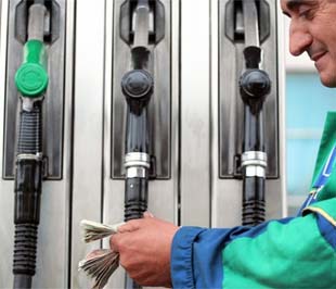 Nhân viên một trạm bán xăng tại Tirana, thủ đô Albany đang kiểm tiền. Áp lực mất giá đối với xăng dầu hiện đang khá ở mức khá lớn - Ảnh: AFP.