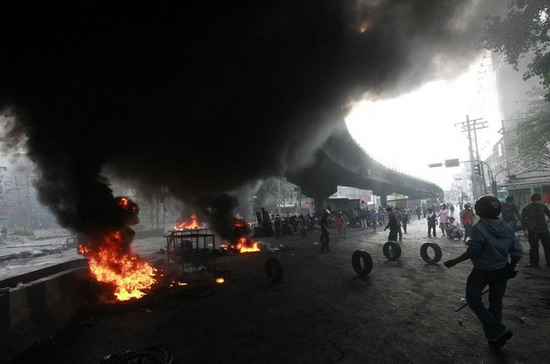 Người biểu tình áo đỏ đốt lốp ôtô trên đường phố Bangkok sáng 16/5 - Ảnh: Reuters.