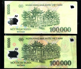 Tờ tiền giả 100.000 đồng in trên giấy nhựa bên trên, bên dưới là tờ tiền thật - Ảnh: D.Đ.Minh.