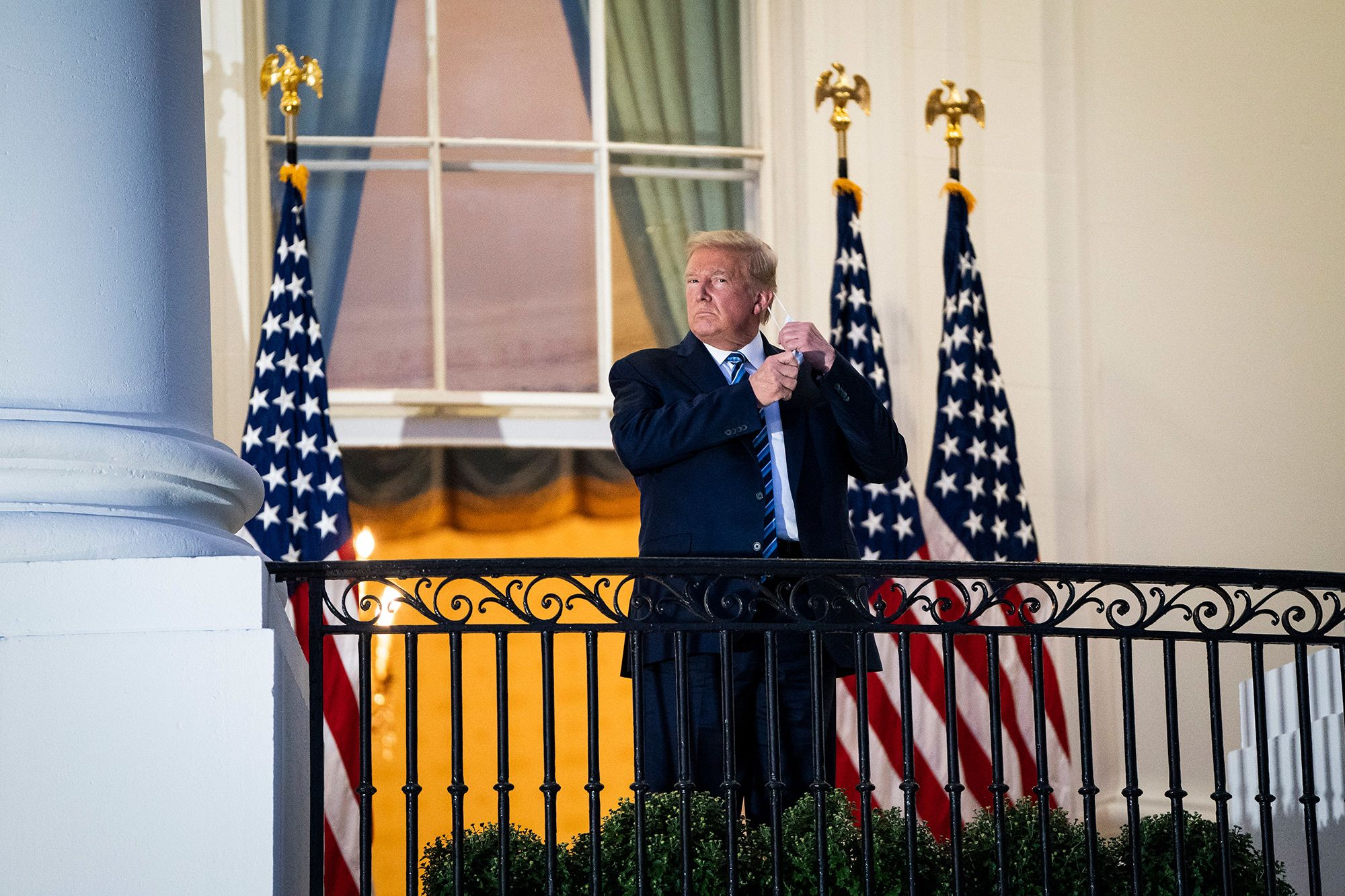 Ngày 1/10, Tổng thống Mỹ Donald Trump được xác nhận dương tính Covid-19 và được đưa đến điều trị tại Trung tâm Y tế Walter Reed một ngày sau đó. Tới chiều 5/10, ông tuyên bố hết bệnh và trở về Nhà Trắng. Trong ảnh là ông Trump cởi khẩu trang để chào phóng viên sau khi trở về Nhà Trắng từ bệnh viện. 