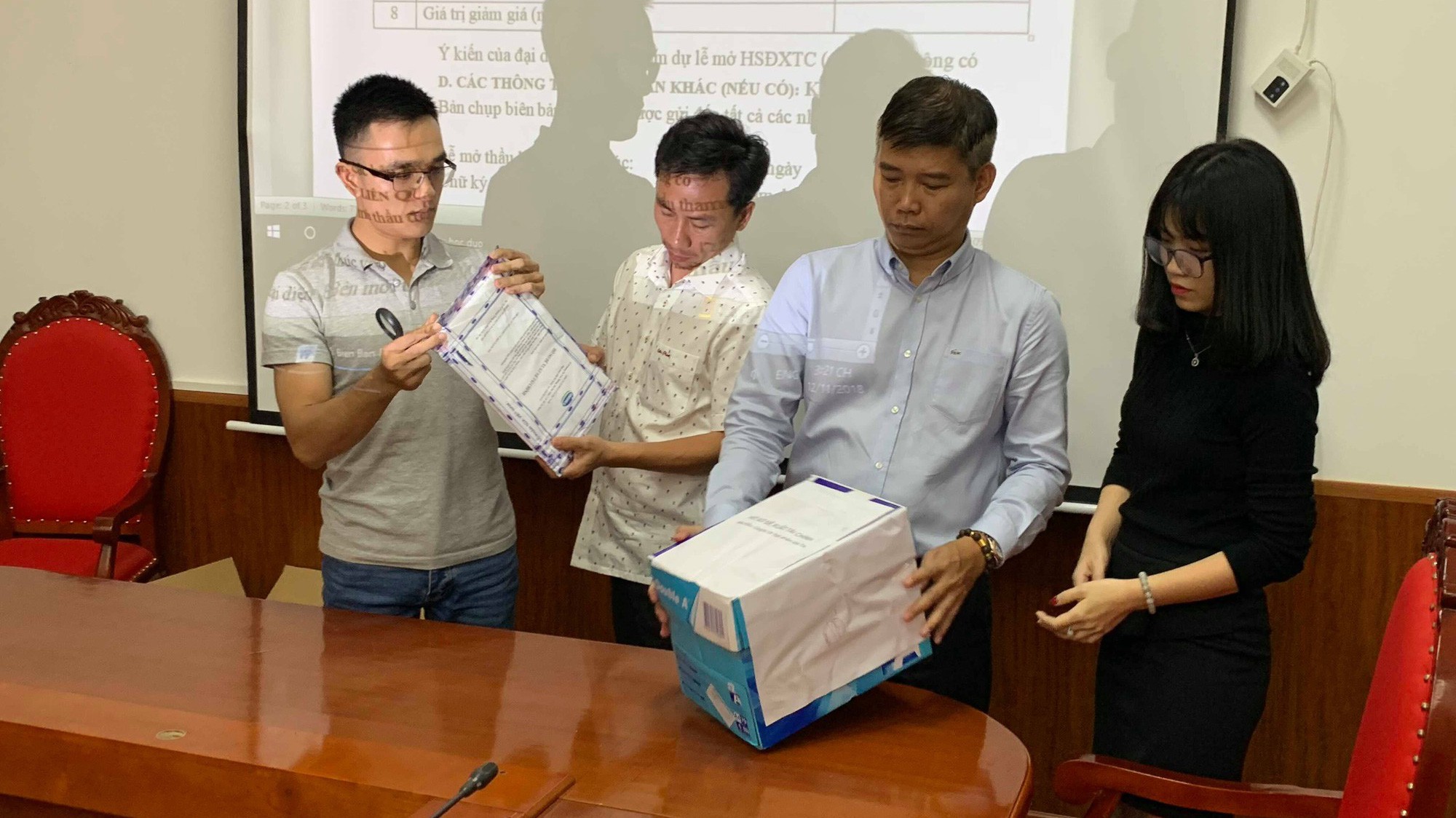 Các doanh nghiệp dự thầu kiểm tra việc niêm phong hồ sơ mời thầu. 