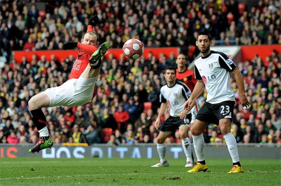 Tiền đạo Wayne Rooney (áo đỏ) của Manchester United (MU) tả xung hữu đột trên sân cỏ. Tuy nhiên, tình hình tài chính của MU lại không tuyệt vời như những gì mà các cầu thủ của họ trình diễn - Ảnh: Getty. 