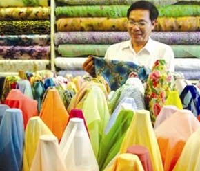 Ông Hồ Viết Lý với những sản phẩm lụa tơ tằm do mình sản xuất.