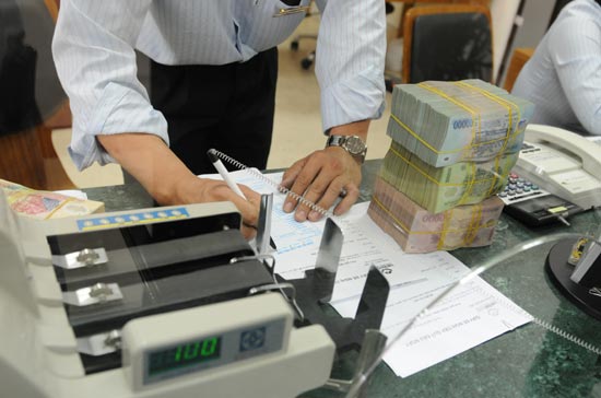 Một số ngân hàng thương mại cho biết, với sự can thiệp của Ngân hàng Nhà nước, lãi suất trên thị trường liên ngân hàng đã giảm mạnh; các kỳ hạn ngắn đã rút xuống dưới 12%, kỳ hạn 1 tuần chỉ còn 11%, lãi suất cho vay qua đêm chỉ còn 8,5%/năm - Ảnh: Quang Liên.