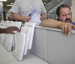 Một người đàn ông đang làm thủ tục xin trợ cấp thất nghiệp lần đầu qua điện thoại tại một trung tâm hỗ trợ nghề nghiệp ở bang Nevada hôm 23/4. Số lượng người thất nghiệp ở Mỹ đã liên tục lập kỷ lục trong 12 tuần qua - Ảnh: AP.