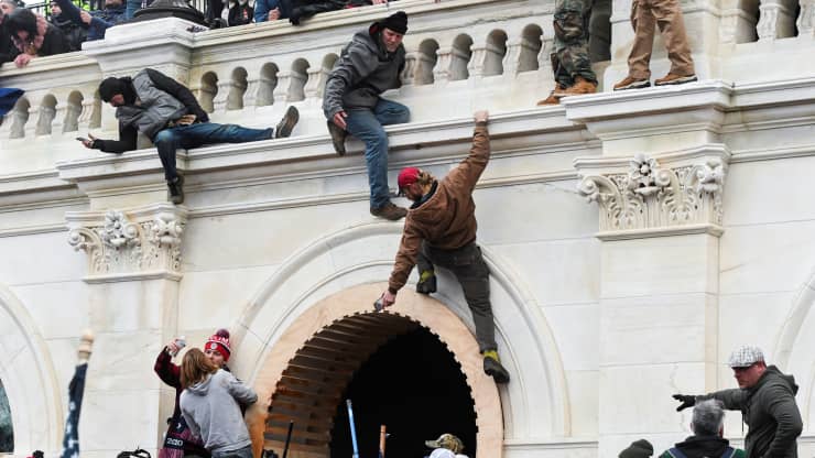 Người biểu tình thân ông Trump trèo tường ở tòa nhà Quốc hội Mỹ ngày 6/1  - Ảnh: Reuters.