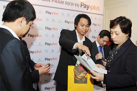 Các kỹ thuật viên đang hướng dẫn khách hàng sử dụng sản phẩm ví điện tử Pay-plus.