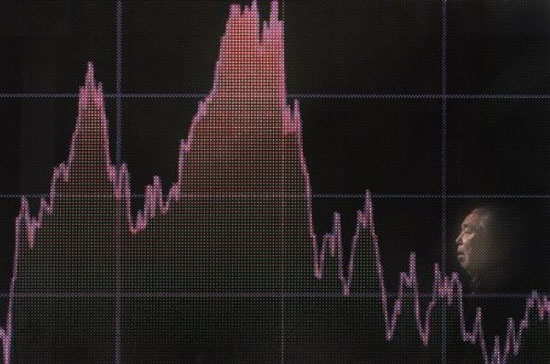 Một người đàn ông đi ngang qua bảng chứng khoán điện tử trên đường phố Tokyo hôm nay, 24/11. Thị trường tài chính châu Á đã rúng động sau cuộc đụng độ giữa hai miền Triều Tiên - Ảnh: AP.