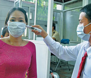Giáo viên học sinh Trường Trung học Á Châu, quận 3, Tp.HCM, được đo thân nhiệt và mang khẩu trang trước khi vào lớp - Ảnh: P. Vy.