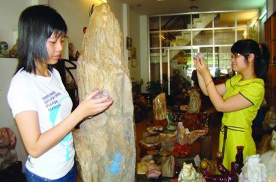 Nhân viên một cửa hàng bán các vật phẩm phong thủy và thạc anh đang chuẩn bị cho một ngày kinh doanh mới - Ảnh: U.V.