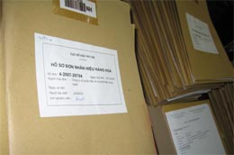 Chồng hồ sơ đăng ký nhãn hiệu trên bàn xét nghiệm viên của Cục Sở hữu trí tuệ.