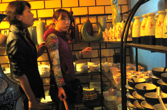 Khách du lịch Nhật Bản chọn mua hàng tại một cửa hiệu đồ gốm ở Bát Tràng - Ảnh: Anh Quân.